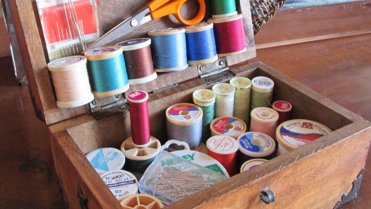 Kit couture débutant rangé dans une boîte avec fil, aiguilles et accessoires