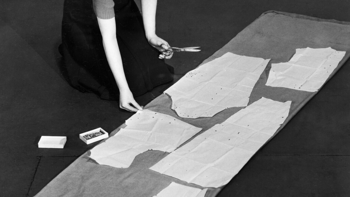 Femme découpant du tissu à partir de pièces de patron de couture